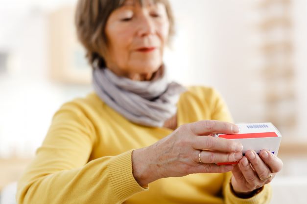 woman looking at medicines pack